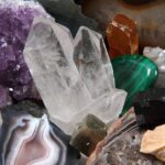 A pile of gemstones, including amethyst, selenite, jasper, jade, and tiger's eye. They're gathered on top of each other.